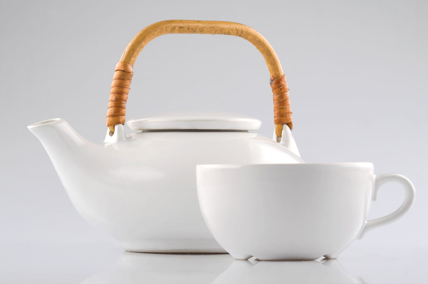 Kanna och kopp mot vit bakgrund.